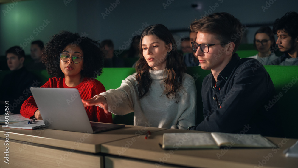 Poster Group of Diverse Happy Students Having a Conversation in University Classroom, Working on a Shared Research Project on a Laptop Computer. Classmates Working Together on College Homework