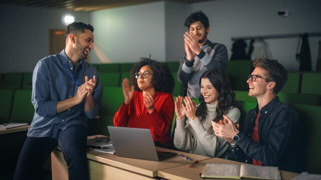 Diverse Students Having a Conversation with a Teacher in University Classroom, Applauding to Celebrate the Completion of a Research Project. Classmates Working Together on College Homework