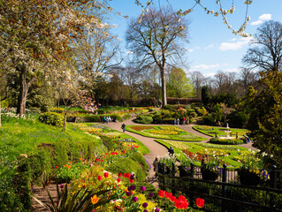 Vibrant colourful flower beds, trees and shrubs in the beautifully landscaped sunken Dingle Garden in Quarry Park, Shrewsbury, UK. 