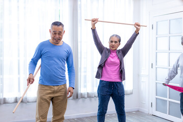 Seniors  stretching exercise together at retirement center. Old people exercise at home. Retired Person exercising at nursing home. Active seniors exercising in home. Sport and recreation concept.