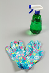 Garden gloves and pressure sprayer on gray background.