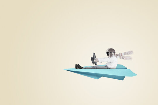 Young boy riding paper plane