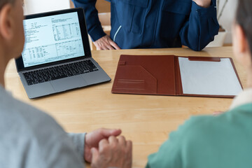 PCを見せながら説明をする日本人男性