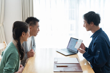 見積もりを出す作業着を着た男性