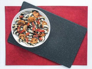 Black Striped Pasta with Mushrooms and Tomatoes on Black and Red