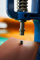 Close-up of the master's hands sewing handmade leather products. A men's tanner connects the parts,...