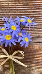 lilac and blue flowers, a small bouquet on a wooden background