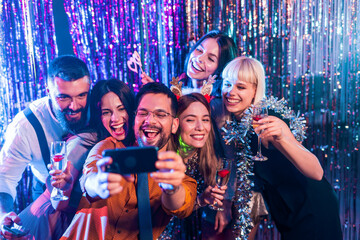 Group of people dancing in the club and make selfie photo.