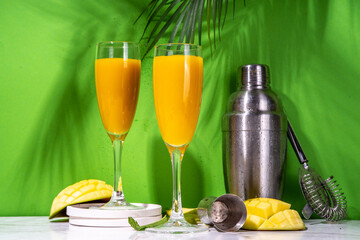 Mango mimosa or  bellini cocktail, summer refreshing cool fruit drink with fresh sliced mango...