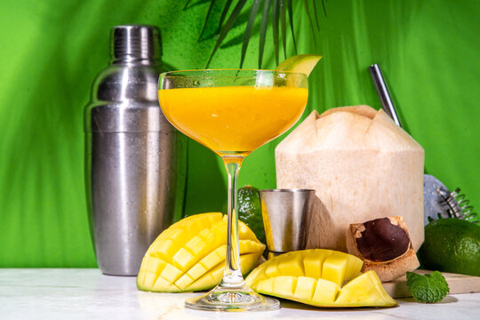 Mango daikiri or martini cocktail, Sweet tropical daiquiri mocktail with fresh coconut water and mango juice, on high-colored background