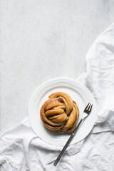 top view of Swedish cinnamon buns on a white plate, cinnamon twists on a plate, top view of homemade Kanelbullar