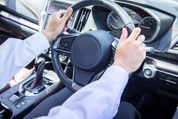 Naklejka premium 車のハンドルを握る手元 hand holding the steering wheel of a car