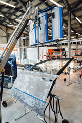 The car body after the accident is covered with putty, primer before painting. The process of disassembled and prepared for painting in the paint chamber by spraying. Service station. Restoring after