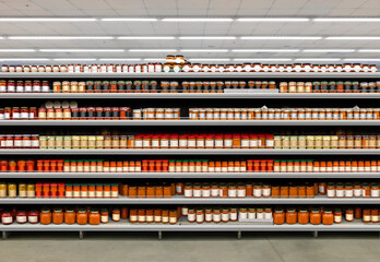 Salsa chili sauce-dip jars for pasta, spaghetti and nachos with brand less labels on shelf in the supermarket - obrazy, fototapety, plakaty