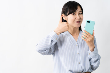 Naklejka premium スマートフォンを持ちながらグッドサインをする若い女性
