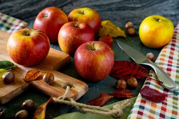 Arrangement of apples, nuts and leaves on a slate background