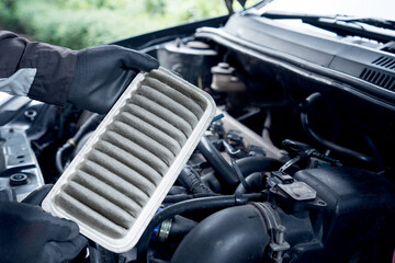 the engine of a car, Concept of car care service maintenance, the car air filter is old and dirty with dust stains for checking cleaning and replacing the new filter.