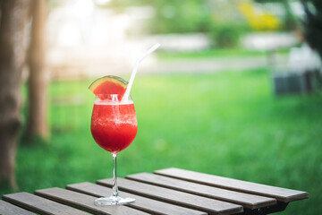 Fresh watermelon smoothie on wooden table in the garden. Healthy water drink for summer.