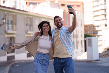 Portrait of a young couple enjoying their fun vacation and taking a selfie