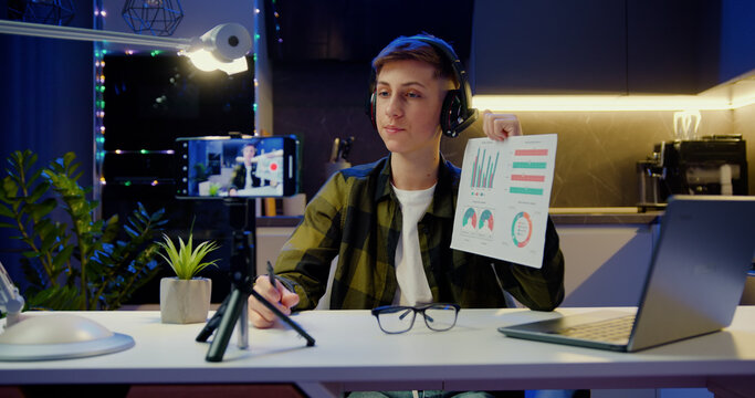Boy using smarthone is live streaming a training blog at home. Chat online with channel subscribers. Home education teenage kids. Communication with subscribers of the stream.