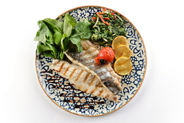 Trout baked in butter with spinach, tomato, rocket and lemon