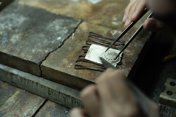 Jeweler at work in jewelry. Desktop for craft jewelry making with professional tools. Close up view of tools. Thailand.	