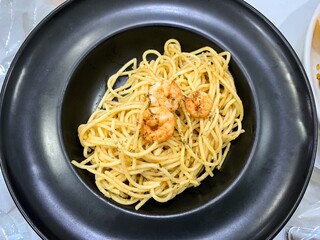 spaghetti aglio olio or napolitan served in black plate.