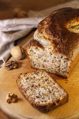 Delicious banana bread with nuts sliced on wooden board