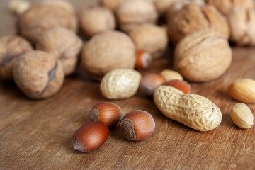 Assortment of nuts. ?azelnuts, walnuts, pistachios, peanuts. Food mix on wooden background, top view, close up.