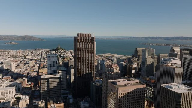 Aerial footage of tall downtown buildings and water in bay in background. San Francisco, California, USA