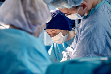 Faces of surgeons close-up during a complex and intense operation, doctors save the patient's life, teamwork of surgeons