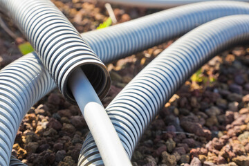Flexible plastic pipeline with electric cable coming out from th