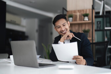 Businessman using laptop computer in office. Happy middle aged man, entrepreneur small business owner.