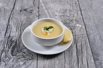 lentil soup with lemon and butter sauce, parsley, in  white bowl