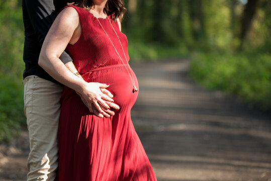 Femme enceinte dans la nature, parents avec les mains en forme de coeur, bola de grossesse