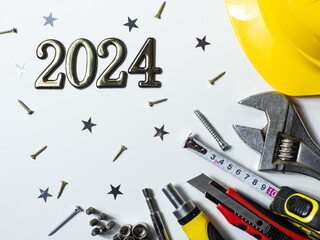 2024 with construction tools, hard hat on white background with small stars and copy space. New Year and Christmas construction greeting card. For advertising or web design. Repair home at Christmas.