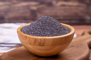 Blue poppy seeds. Spices concept. Blue poppy seeds on wooden background. Close up