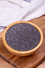 Blue poppy seeds. Spices concept. Blue poppy seeds on wooden background. Close up