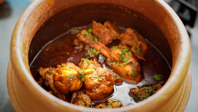 Spicy Indian garlic chicken curry in a clay pot