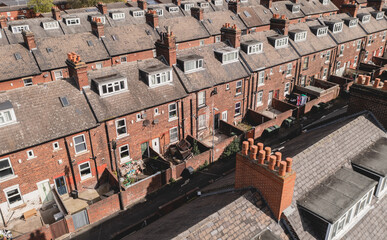 Aerial view above rows of back to back terraced houses on a large council estate