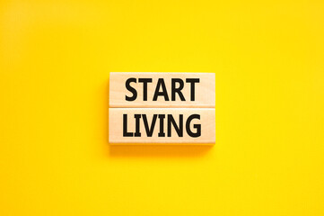 Start living symbol. Concept words Start living on beautiful wooden block. Beautiful yellow table yellow background. Business and Start living concept. Copy space.