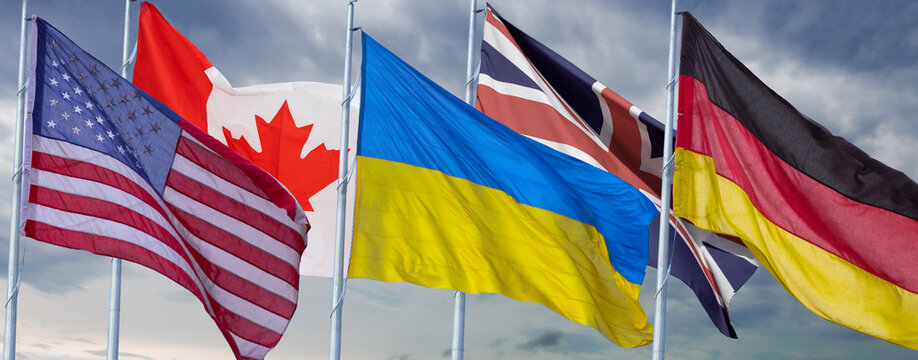 Small flags of different countries on table. Flags of Canada, American, United Kingdom, Ukraineon.