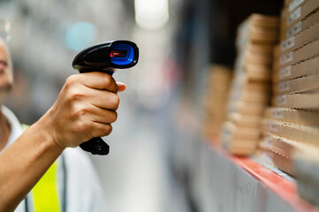 Close-up male engineer scanning goods with barcode scanner checking goods in transportation and distribution in warehouse. Industry and Export Business Concepts