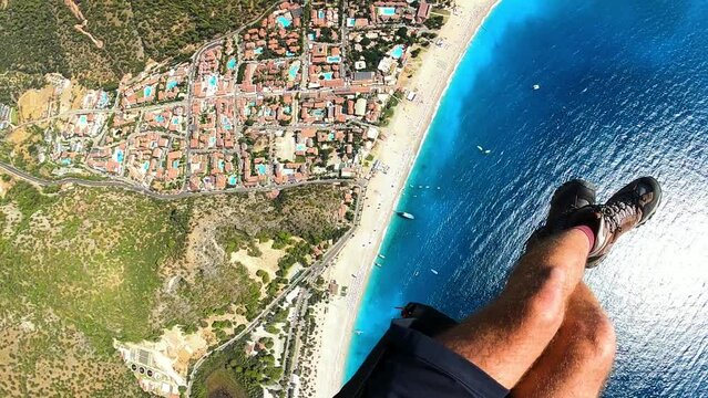 paragliding point of view in Oludeniz. legs paraglider flying over the sea and the beach on sunset. Extreme and active types of recreation. panoramic view from gopro. High quality FullHD footage