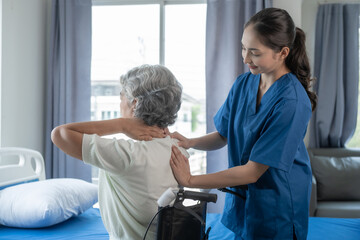 Physiotherapist working with asian elderly female patient woman having chiropractic back...