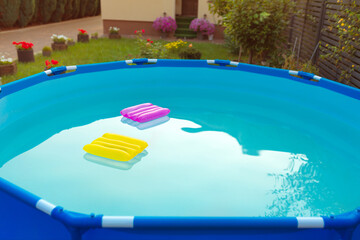 Two inflatable pillows lie on the surface of the water in the pool