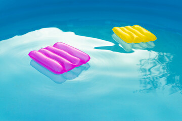 Two inflatable pillows lie on the surface of the water in the pool