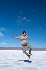 Woman jumping in the Salinas Grandes salt flat, Jujuy