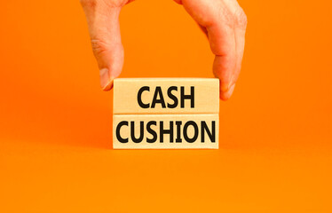 Cash cushion symbol. Concept words Cash cushion on beautiful wooden block. Beautiful orange table orange background. Businessman hand. Business and Cash cushion concept. Copy space.