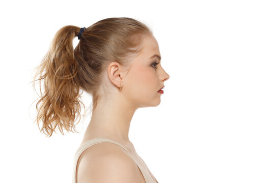Profile, side view of beautiful serious blonde woman with tied hait on a white background